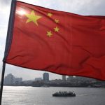 71452981_A-Chinese-tour-boat-cruises-on-the-Yalu-River-behind-the-Chinese-flag-flying-on-the-Bro